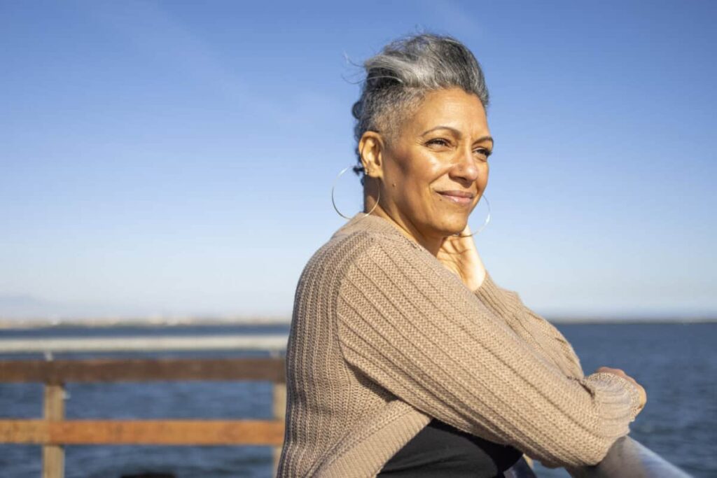 woman looks ahead of her over water