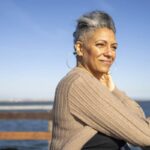 woman looks ahead of her over water