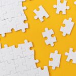 Partially complete jigsaw puzzle with scattered missing pieces