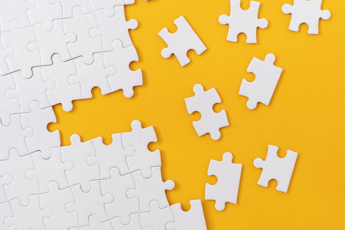 Partially complete jigsaw puzzle with scattered missing pieces