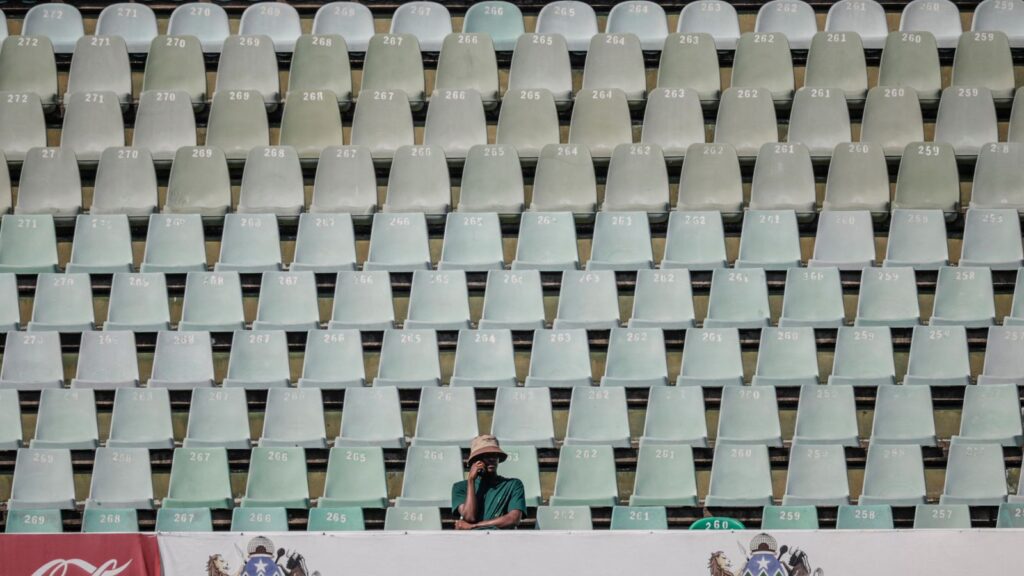 A cricket supporter sits alone in the stands during the first Test between South Africa and Australia in Durban