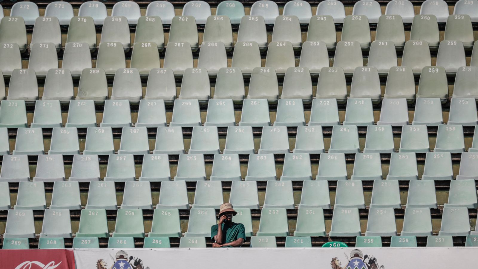 A cricket supporter sits alone in the stands during the first Test between South Africa and Australia in Durban