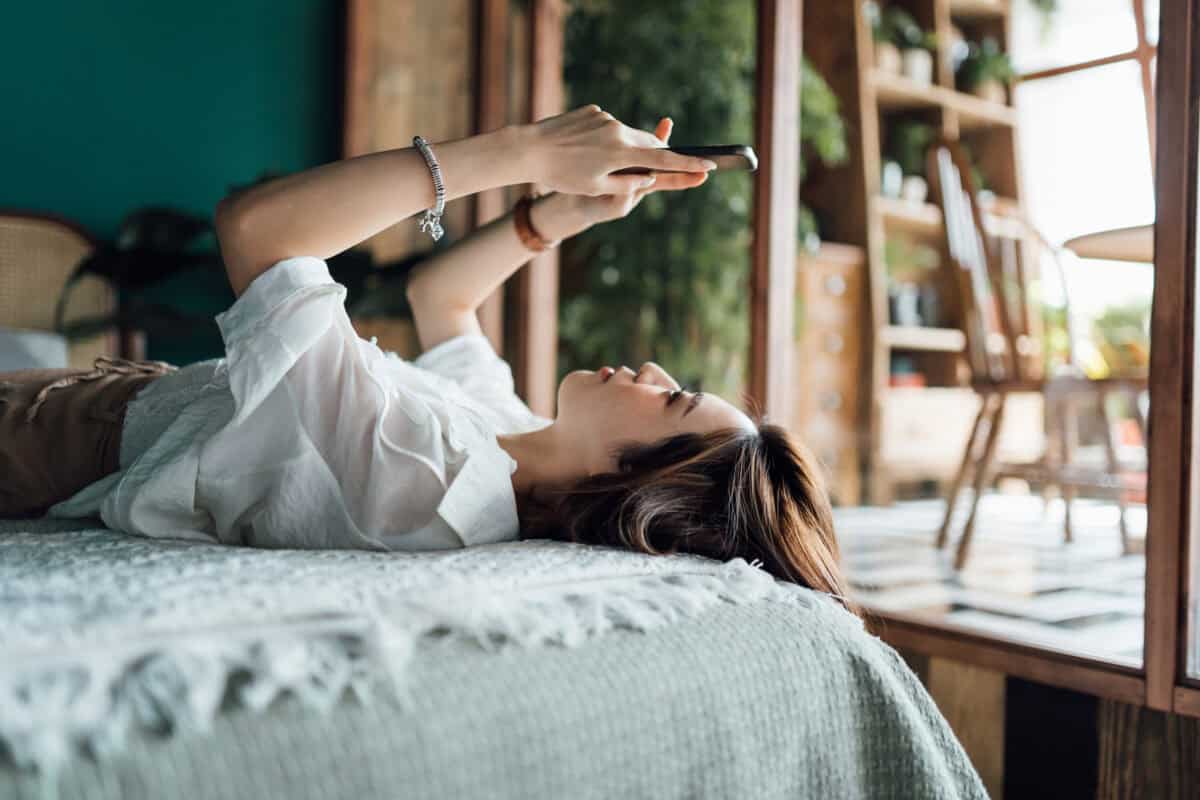 woman relaxes with phone